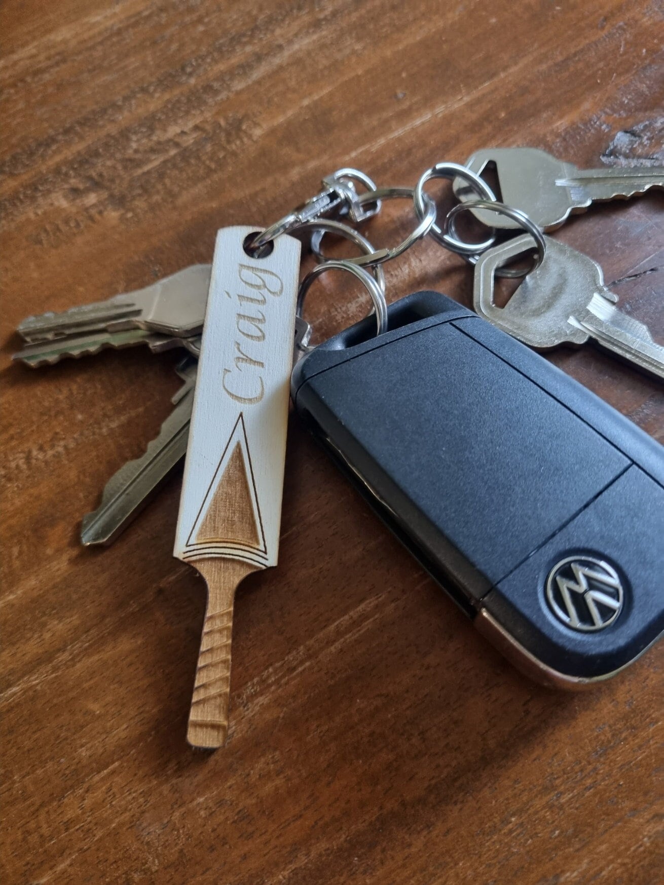 Wooden keyring laser cut and engraved in the shape of a cricket bat. It is personalised with the name Craig.