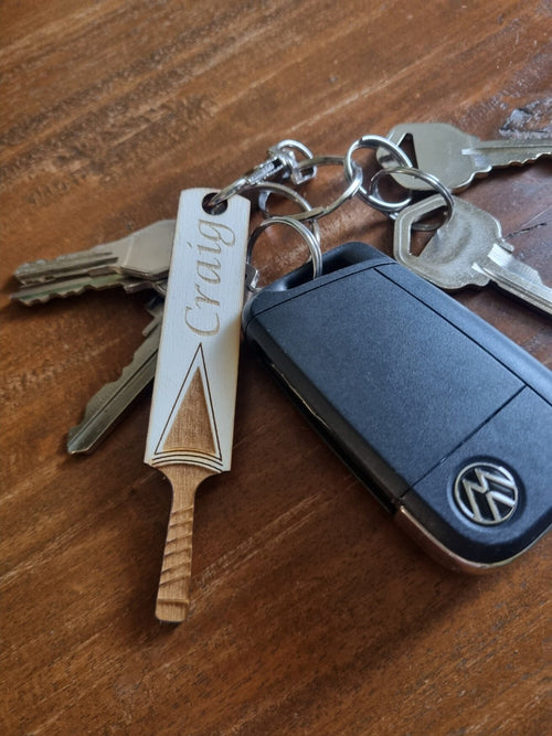 Wooden keyring laser cut and engraved in the shape of a cricket bat. It is personalised with the name Craig.