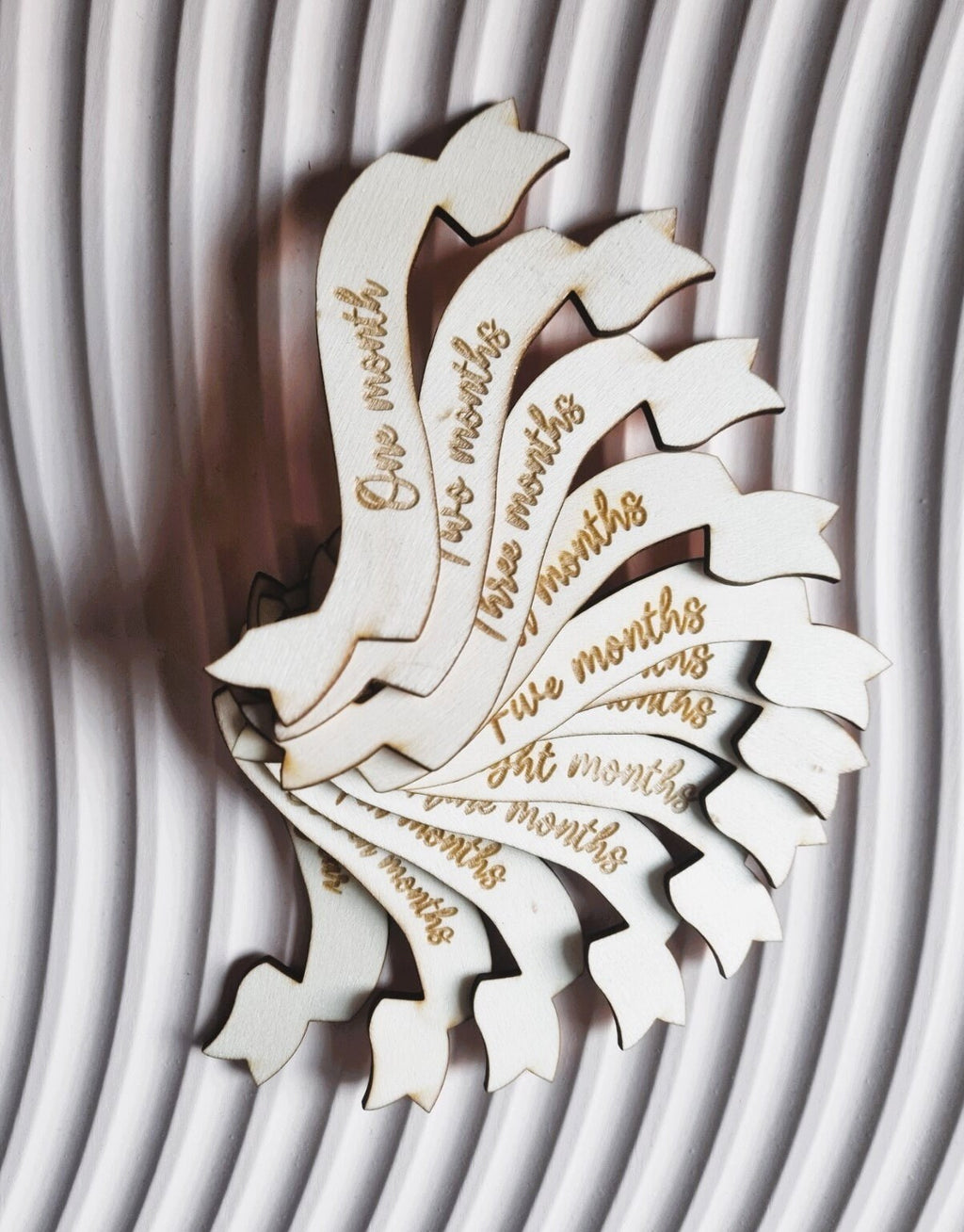 Baby Milestone photo prop set. The main piece is cut in the shape of a hot air balloon and each monthly milestone is engraved on a ribbon shaped piece of wood  that is interchangeable  in the centre of the balloon.