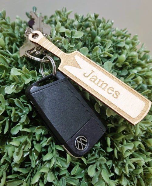 Wooden keyring laser cut and engraved in the shape of a cricket bat. It is personalised with the name James.