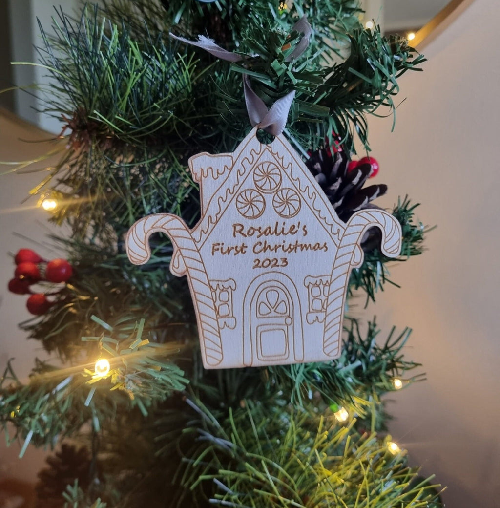Personalised Christmas Tree Ornament made from poplar ply wood. It has been laser cut and engraved in the shape of a christmas gingerbread house and is hanging on a Christmas Tree.