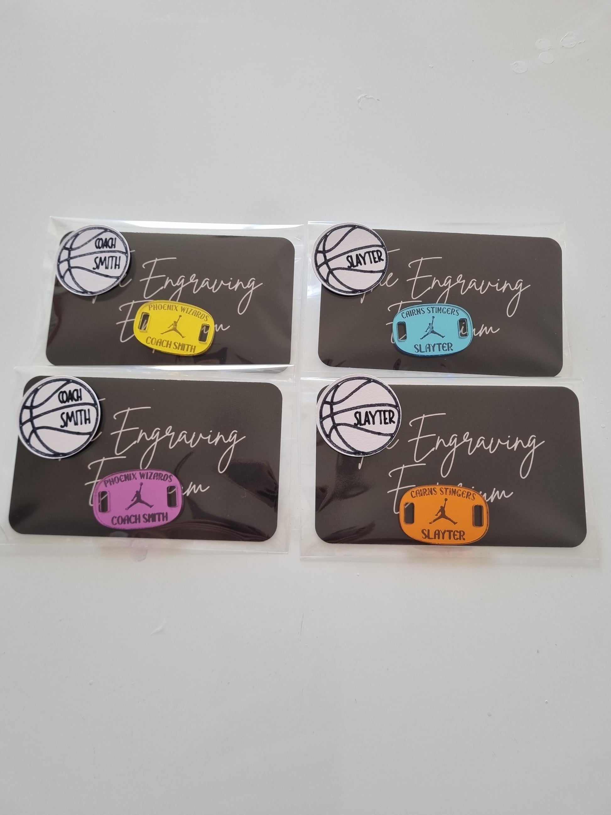 Individually packaged engraved shoe tags, made of baby blue, yellow, orange and purple mirrored acrylic, featuring player names and team name. A thoughtful and unique gift for a basketball team.